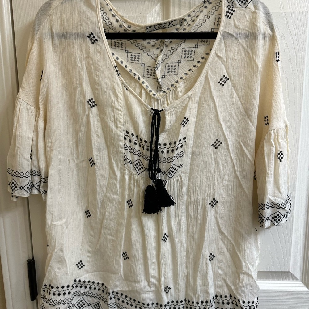 Anthropologie blouse. Ivory with black print and black tassels.